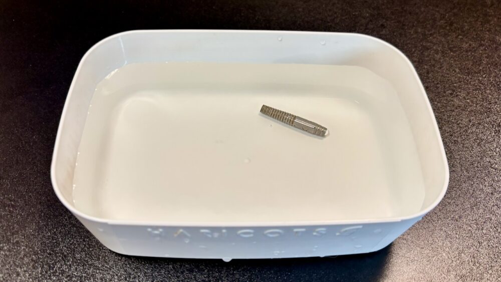 ダーツバレルの汚れをぬるま湯でふやかしている様子