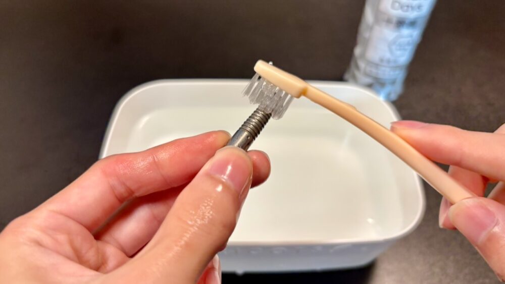 ダーツバレルを歯ブラシと食器用洗剤で洗浄している様子