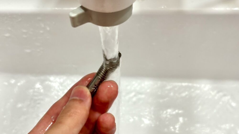 ダーツバレルの洗浄後に流水で洗い流している様子